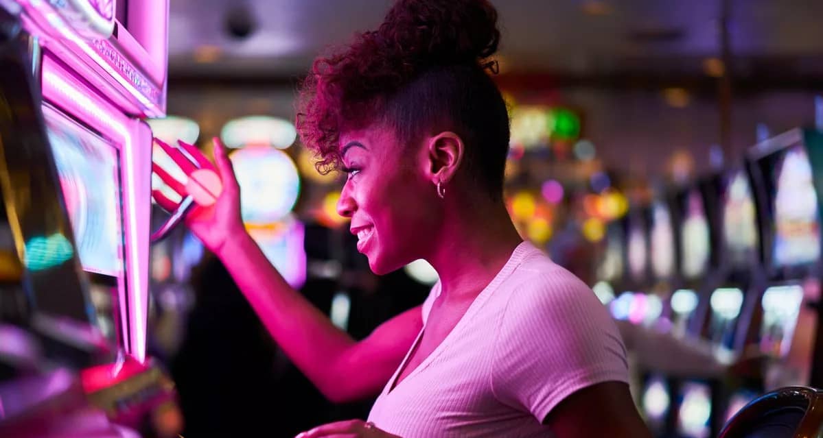 Person smiling while using slot machine in a .width .jpg