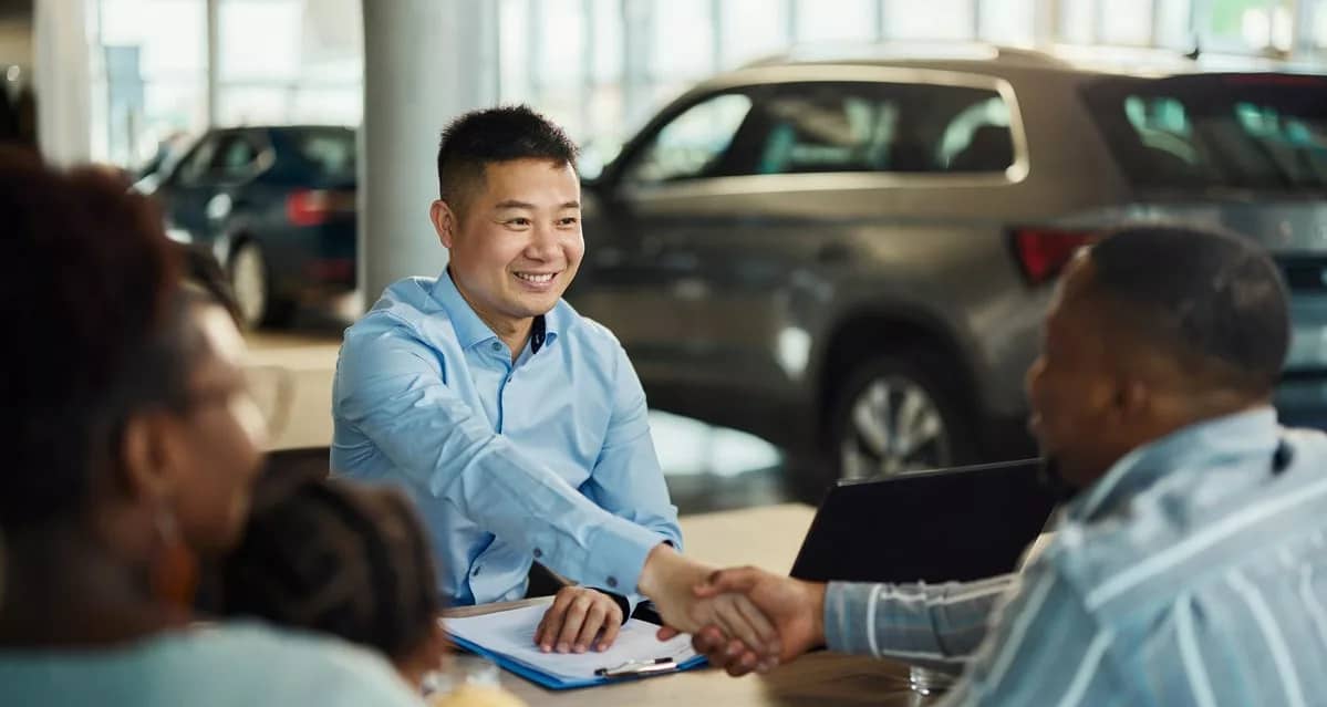 Salesman and customer shaking hands over pape.width .jpg