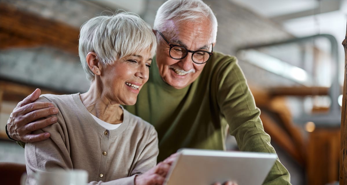 smiling couple looking at tablet together.jpg