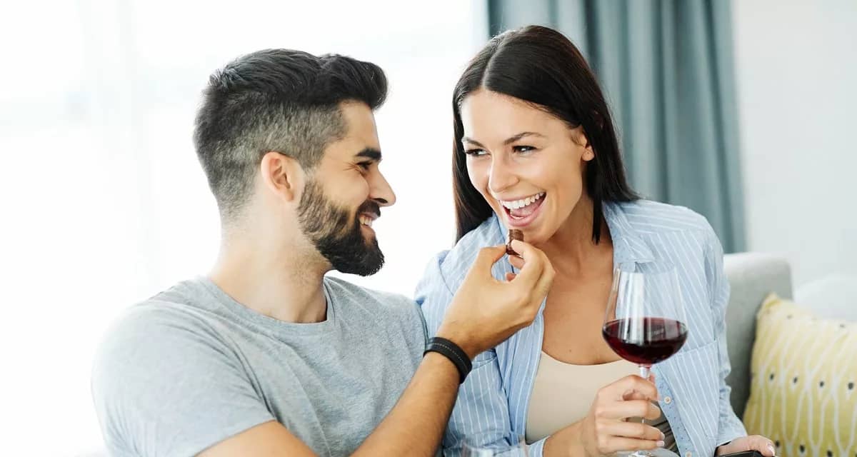 Couple eating chocolates and drinking wine to.width .jpg