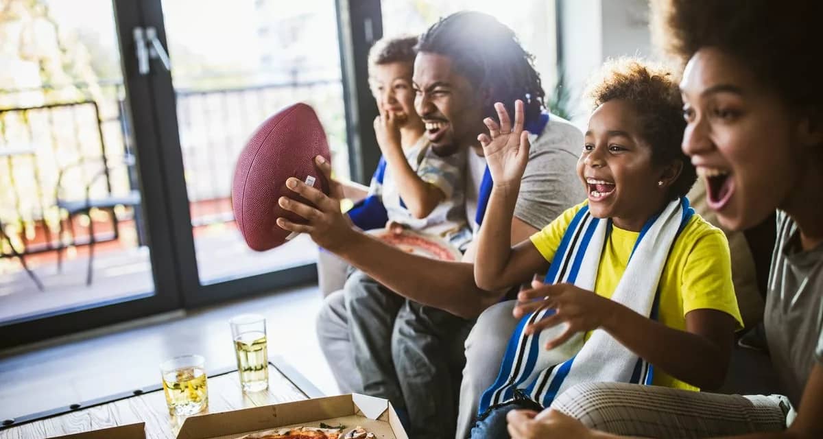 family on couch watching football vgiReM.width .jpg