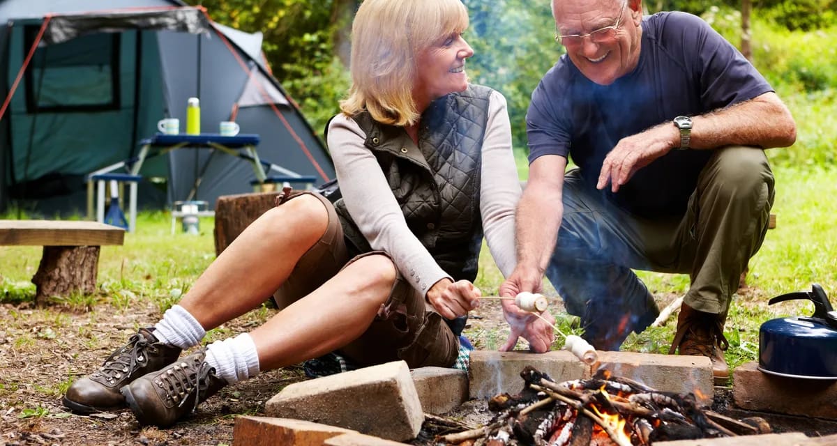 smiling couple roasting marshmallows at campsite.jpg