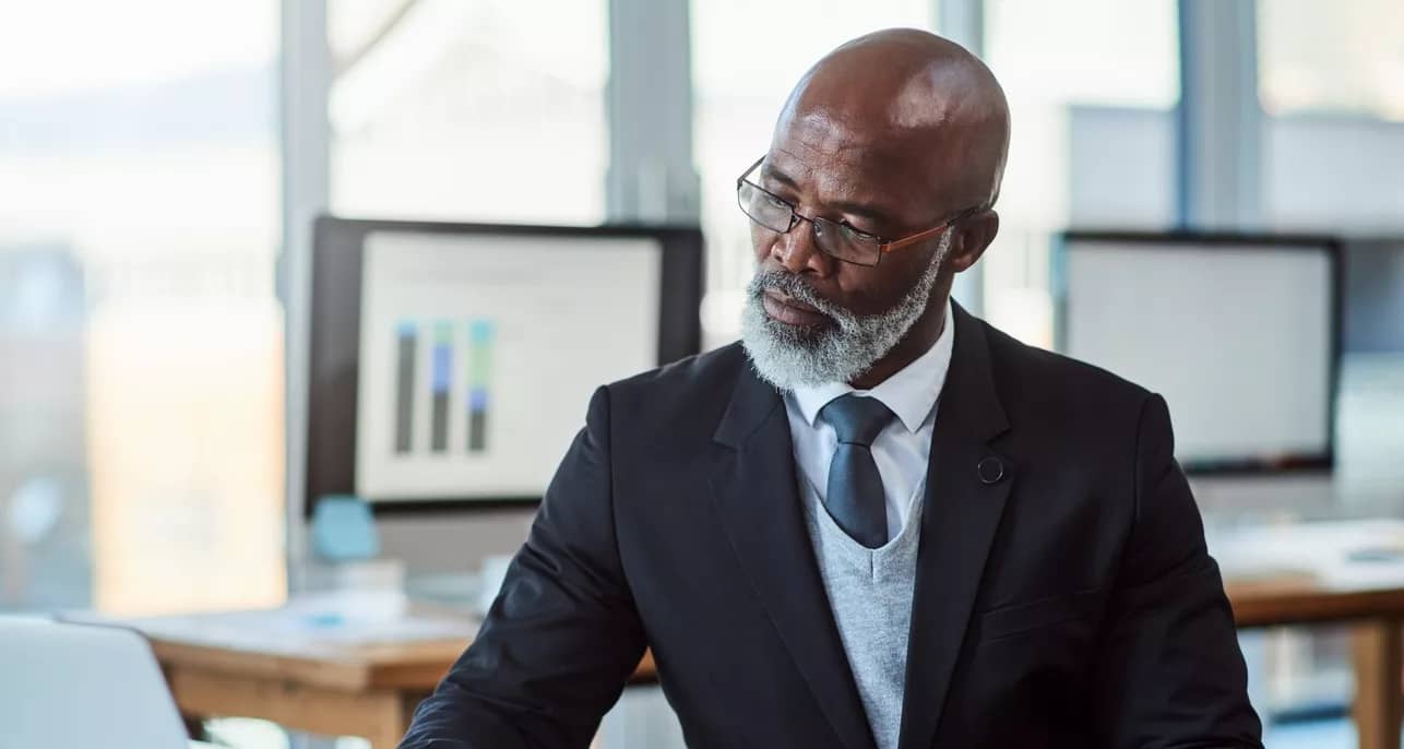 getty person in suit at desk laptop thoughtful thinking x cf.jpg