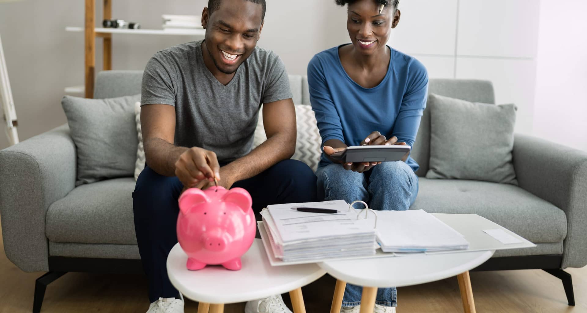couple putting money in a piggy bank gettyimages JHHjH