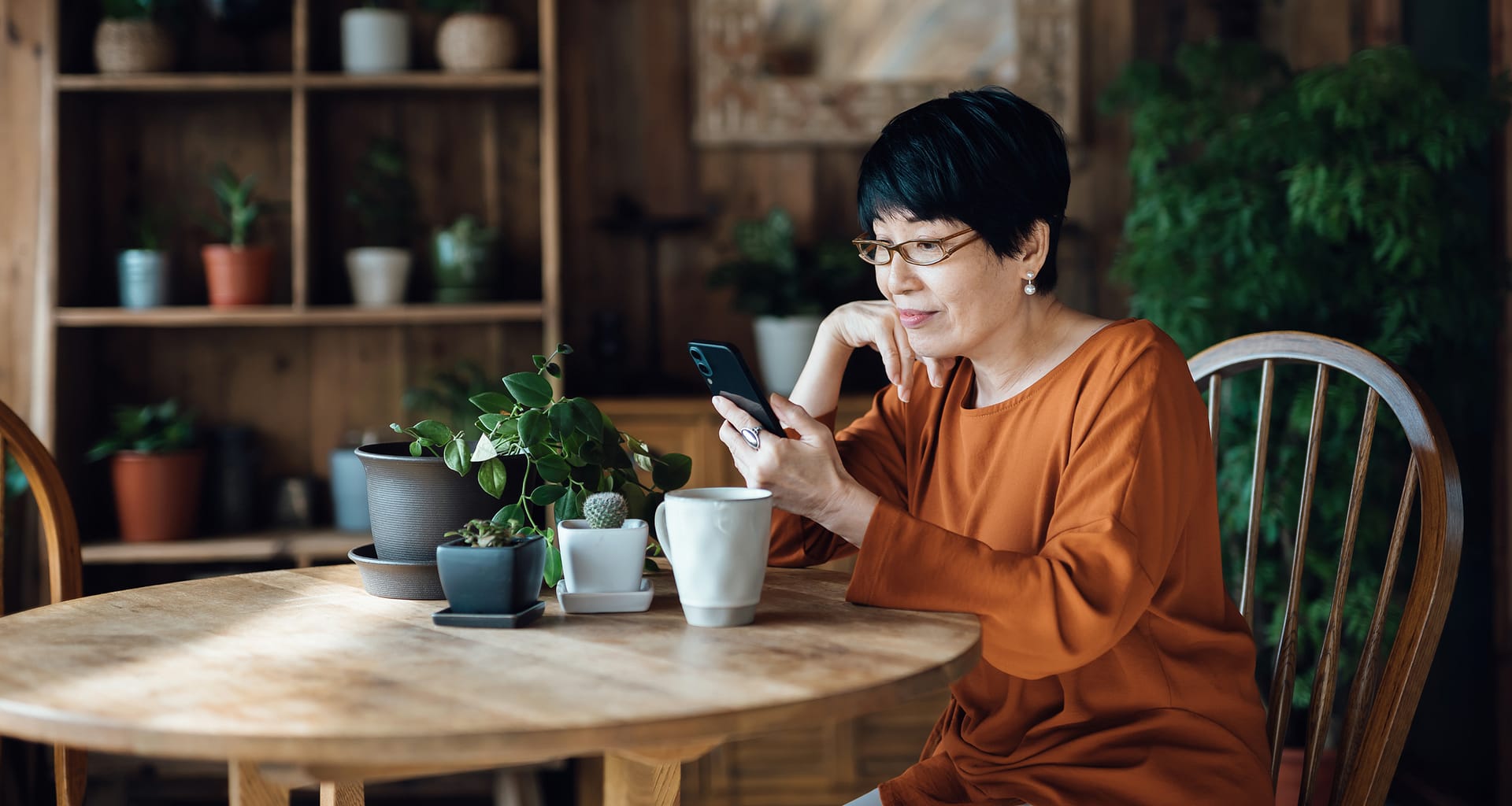 person sitting at a table using a smartphone emKMVr