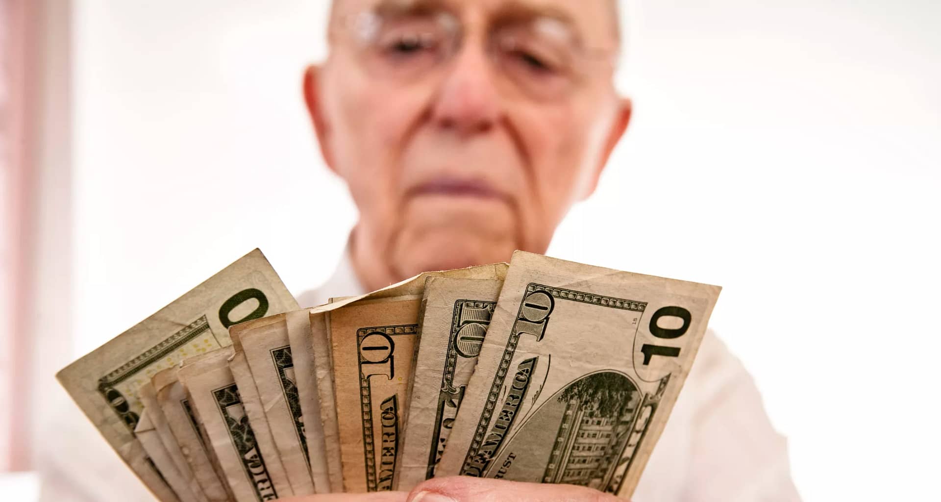 senior holding assortment cash bills social security retire getty.jpg