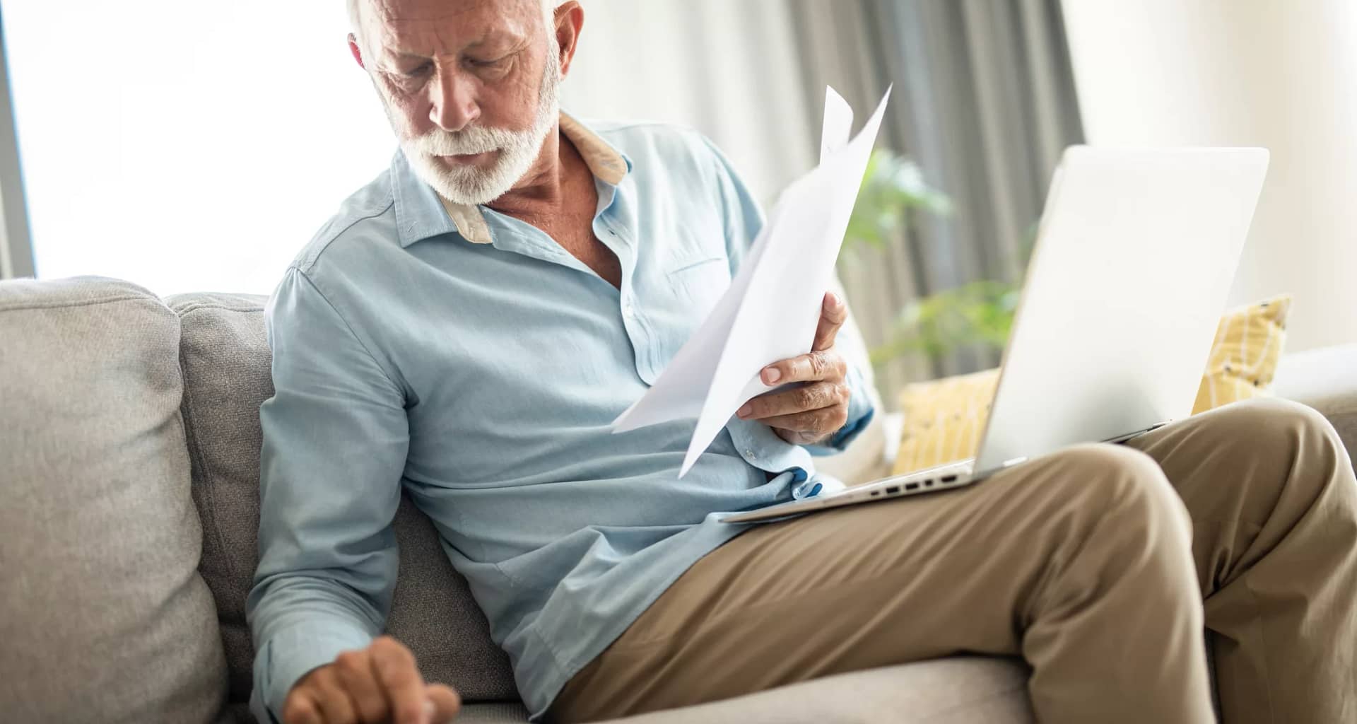 senior man couch docs calc laptop gettyimages .jpg