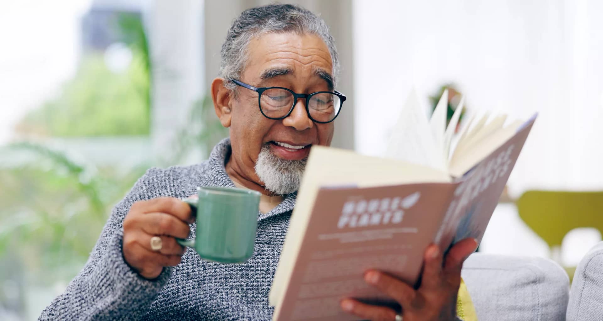 getty smiling happy reading book with mug.jpg