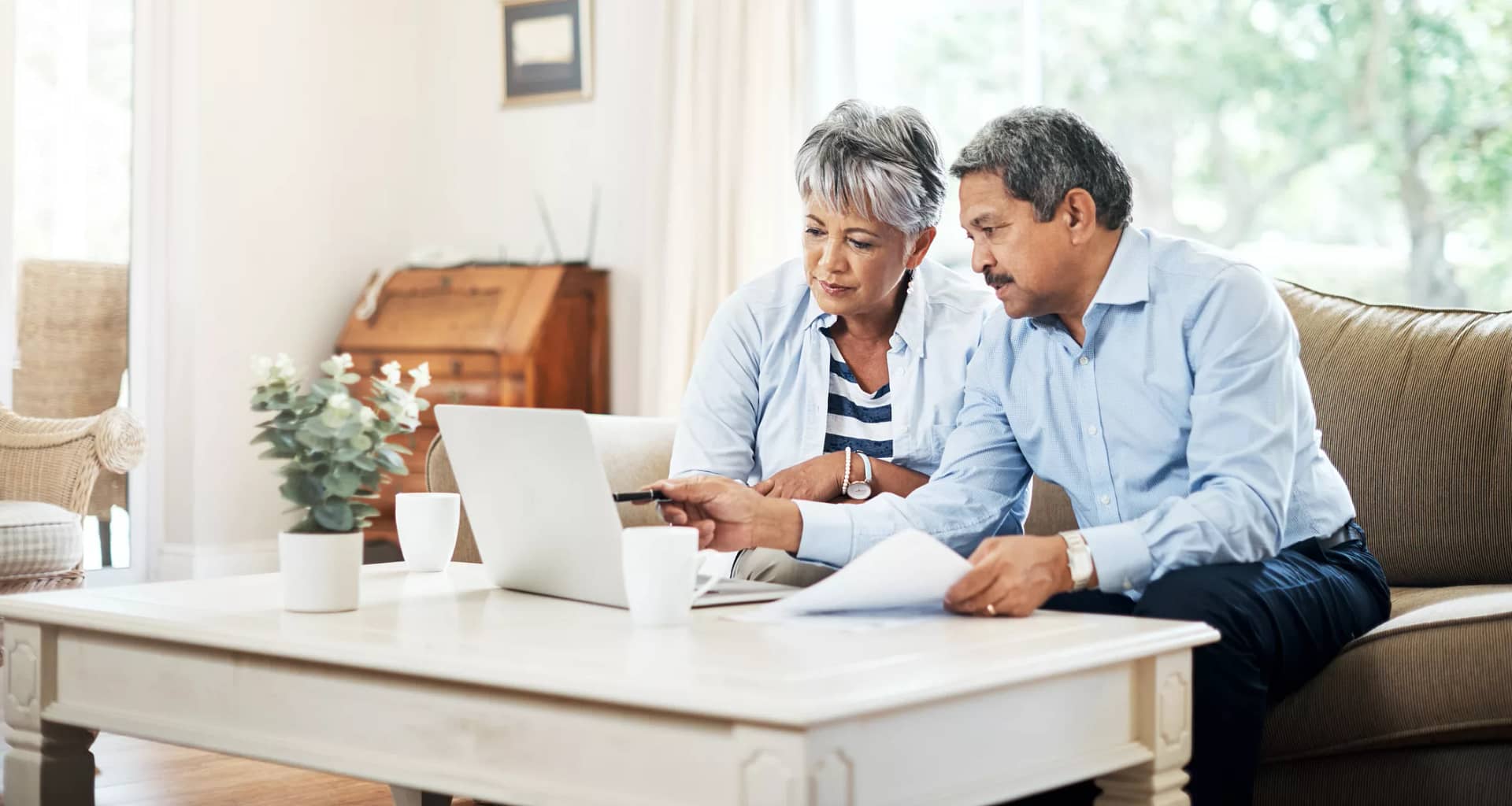 two older people sitting on a couch looking at a laptop copy.jpg