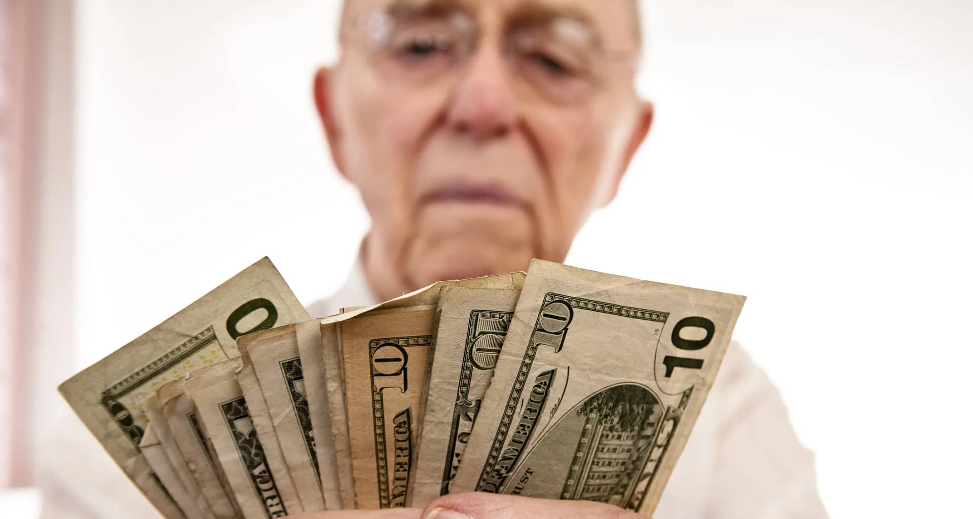 senior holding assortment cash bills social security retire getty.jpg