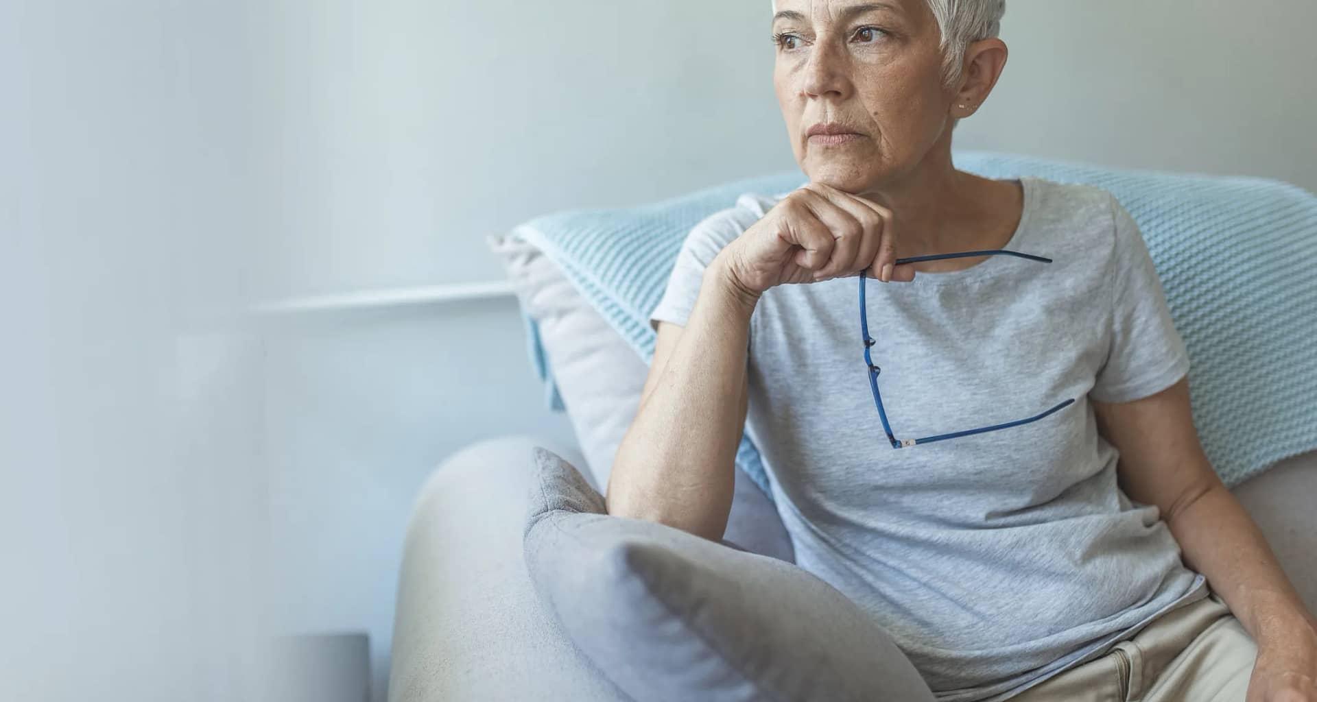 senior woman worried holding eyeglasses gettyimages .jpg