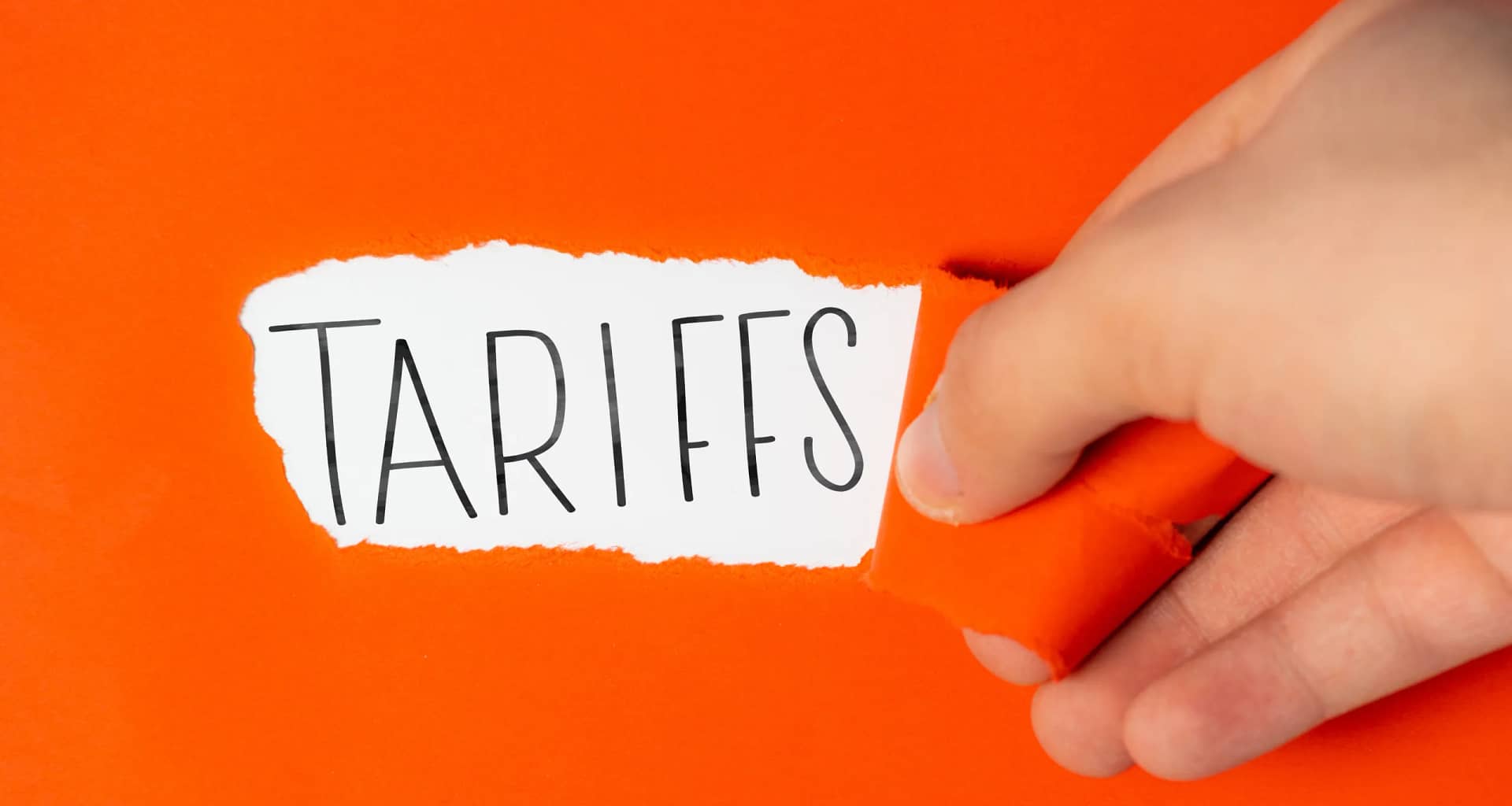 tariffs on torn orange paper.jpg