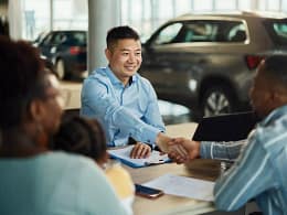 Salesman and customer shaking hands over pape.width .jpg
