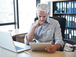 older man desk tablet serious gettyimages .jpg