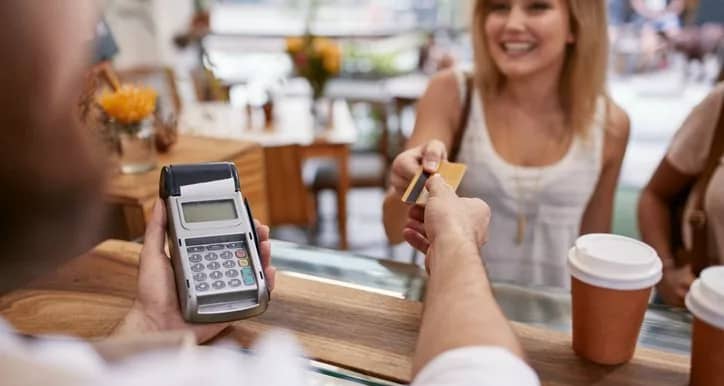 woman handing credit card to cofee shop cashi.width .jpg