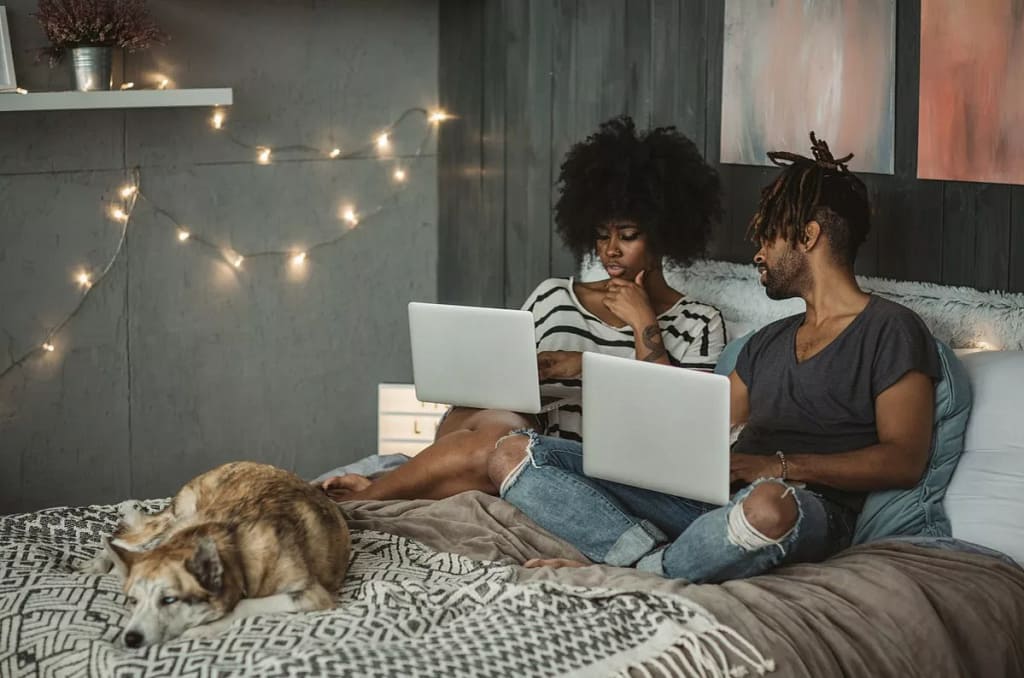 young couple on laptops in bedroom RrGguP.width .jpg