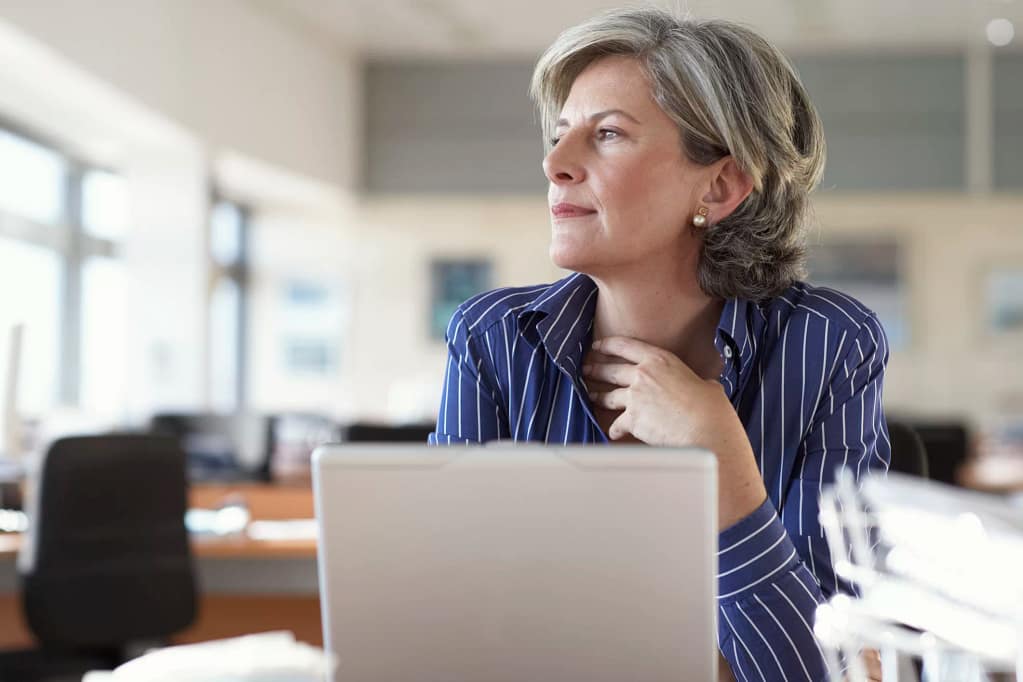 mature woman on laptop thinking and looking out window.jpg
