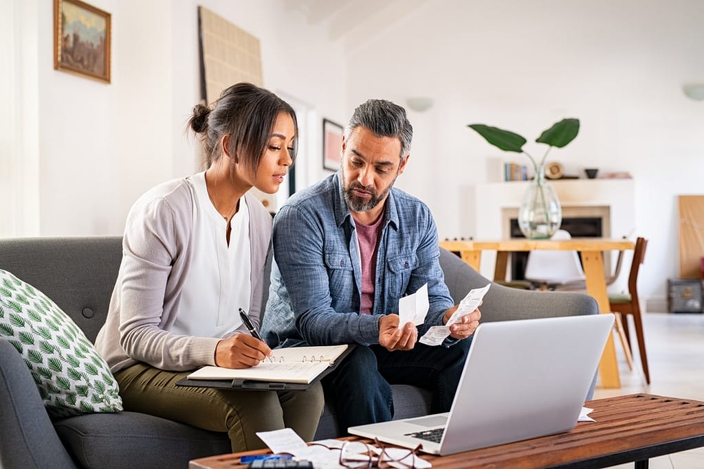 two people a laptop and their bills