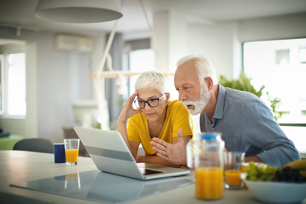 worried couple looking at laptop