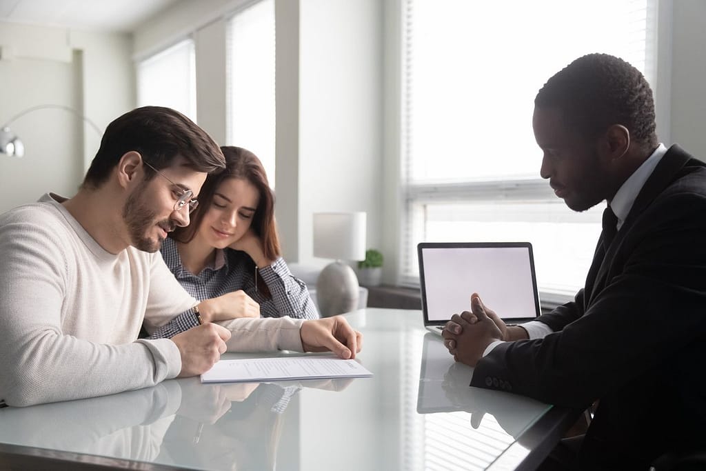 Couple signing paperwork with an agent ooiUfy.width