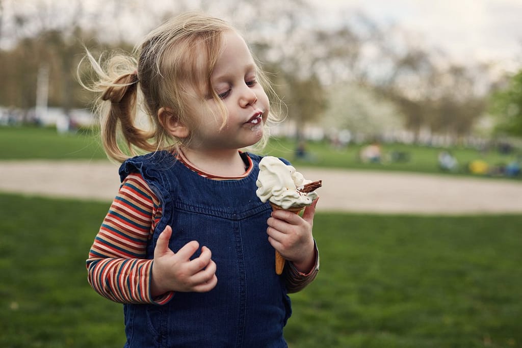 Young girl eating ice cream cone YBZc.width