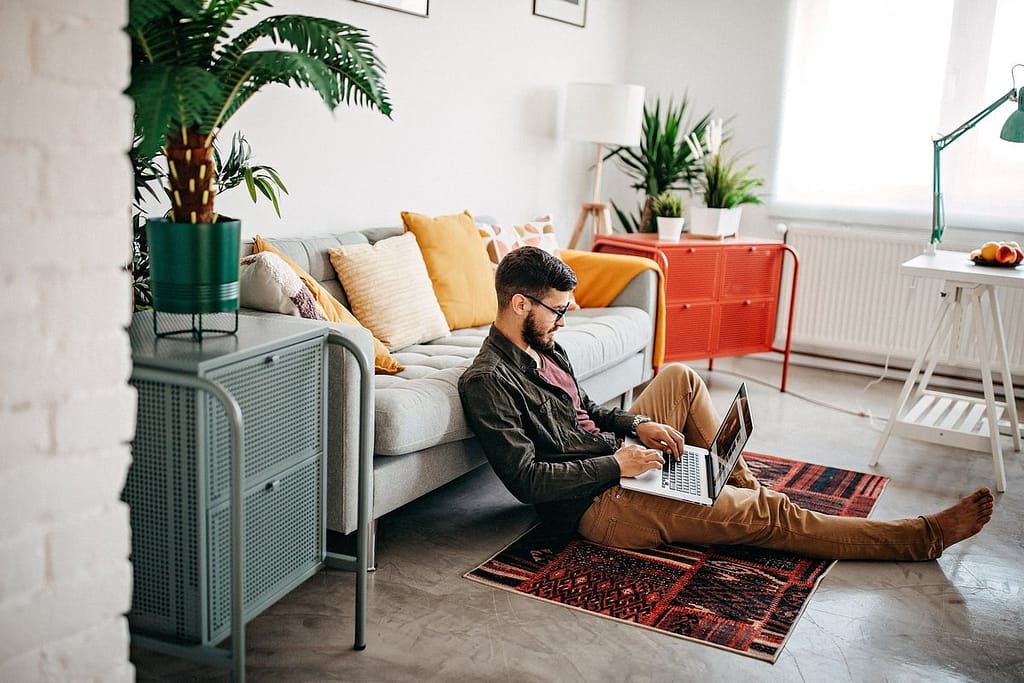 person on living room floor with laptop LRGGF.width .jpg