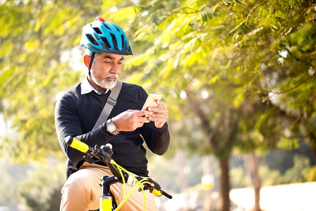 Man looking at his cell phone while riding hi.width TIdVD.jpg