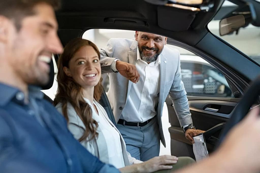 Car salesman assisting coupe with car purchas.width aDiU.jpg