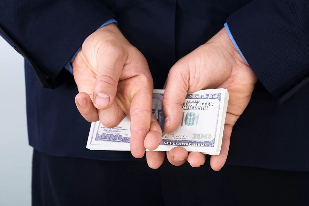 money behind back fingers crossed corporate tax getty.jpg