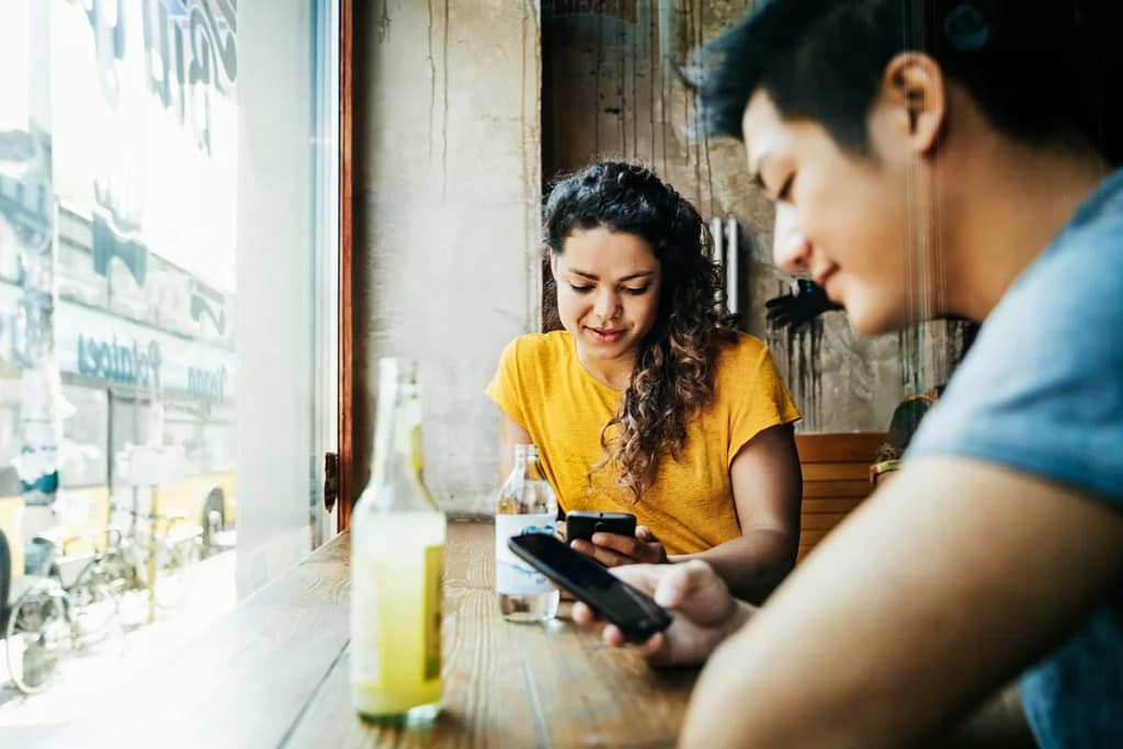 two people with phones in restaurant ZpfzLt.width .jpg