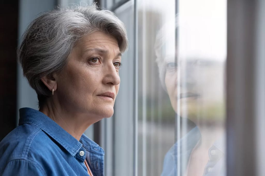 gettyimages worried senior woman looking out window.jpeg
