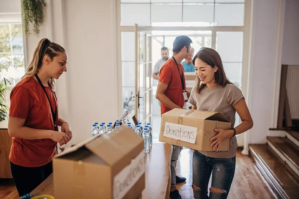 Woman carrying box marked Donations gPzKqVh n.width .jpg