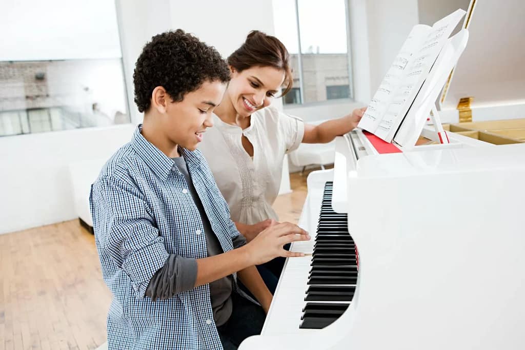 Woman giving young boy piano lessons lHvgOq.width .jpg