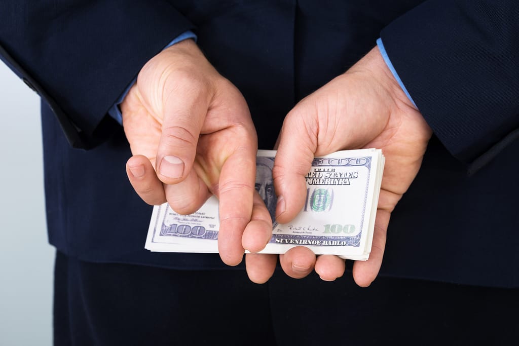 money behind back fingers crossed corporate tax getty.jpg