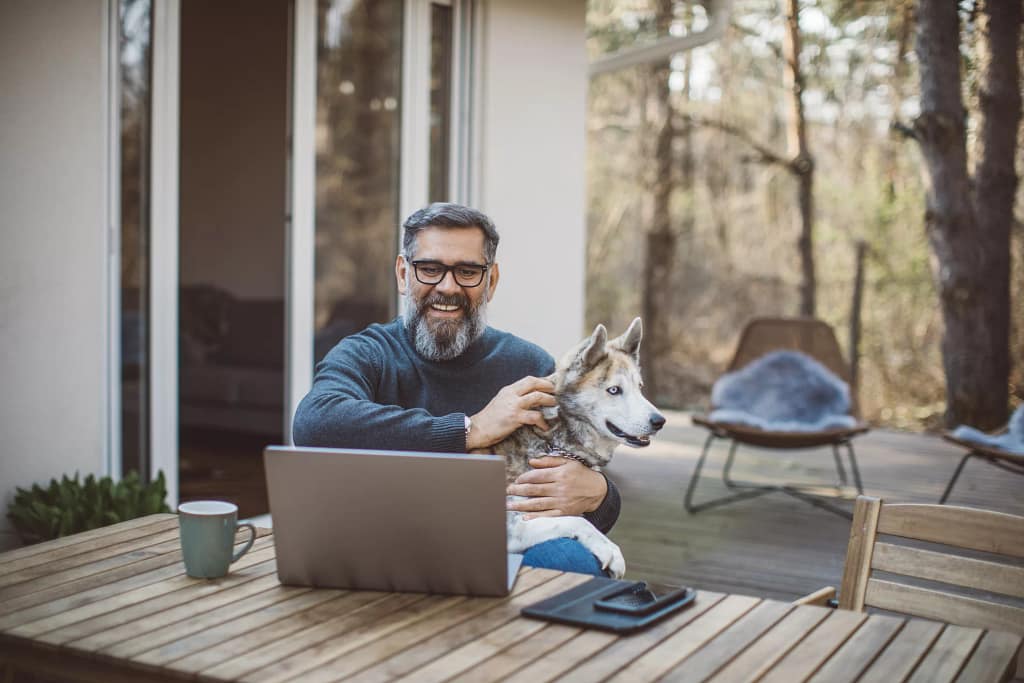 older man at laptop with dog gettyimages .jpg