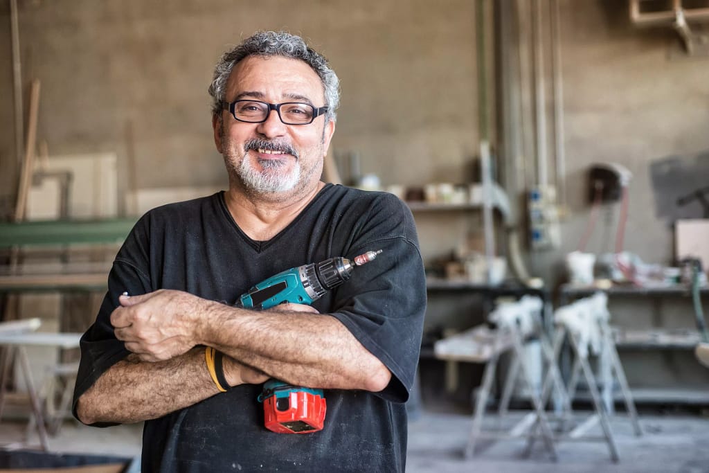 getty smiling happy workers with tool drill blue collar.jpg