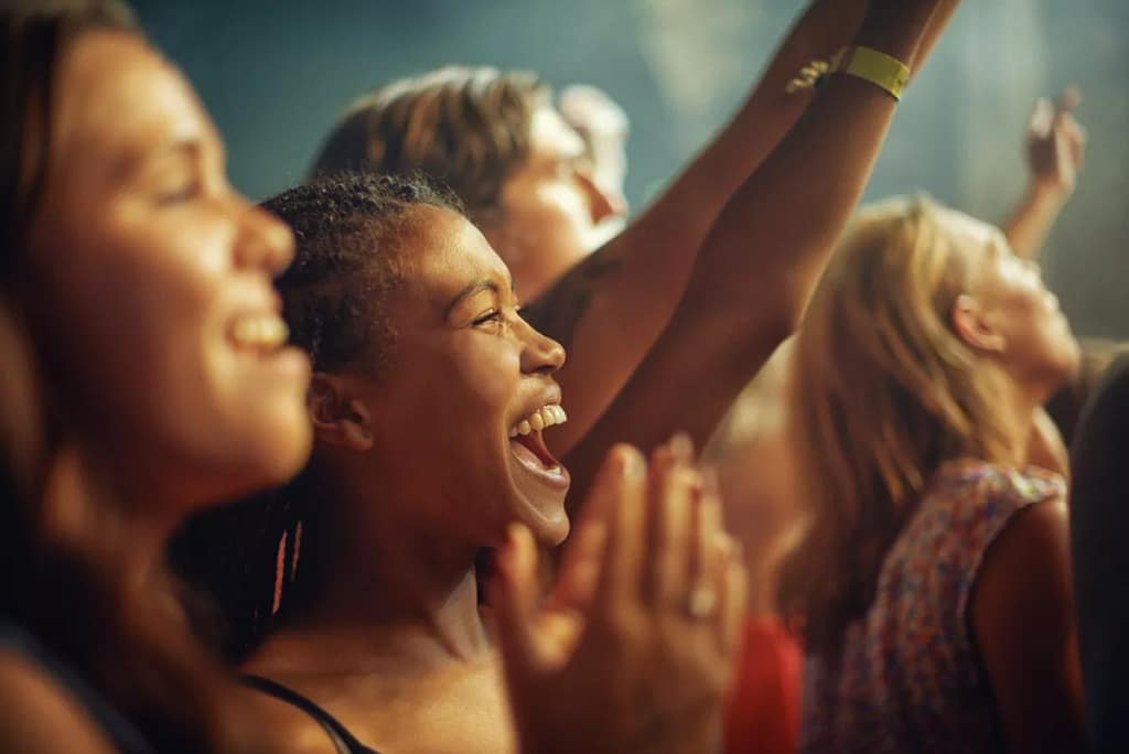 People in a crowd enjoying some form of live .width .jpg