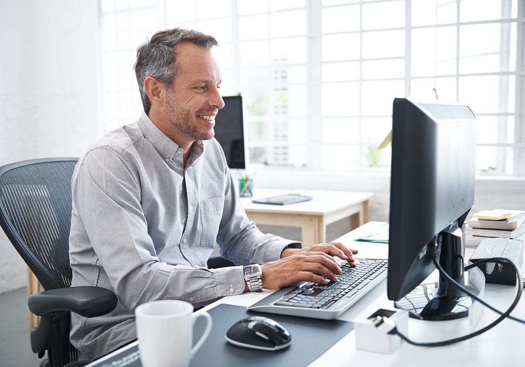 a smiling person at a computer gettyimages .jpg