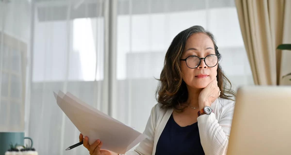 senior holding documents and looking at computer.jpg