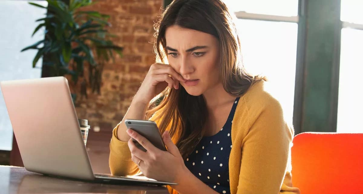 Woman using cell phone with concerned look on.width UczVhr.jpg