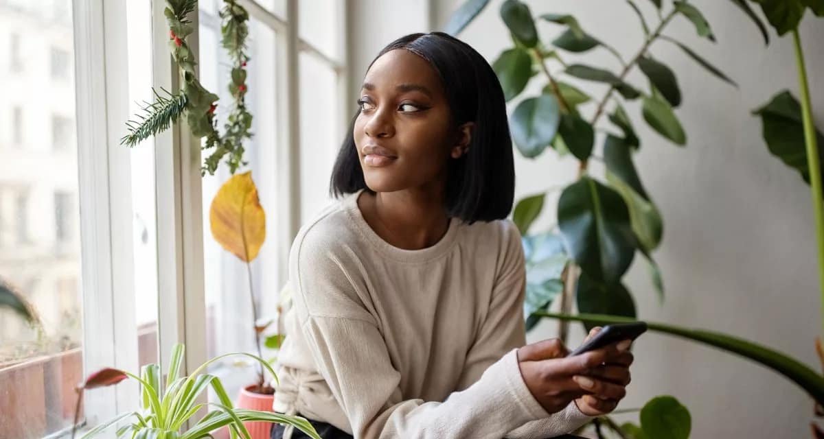 person with phone looking out window ZLNGso.width .jpg