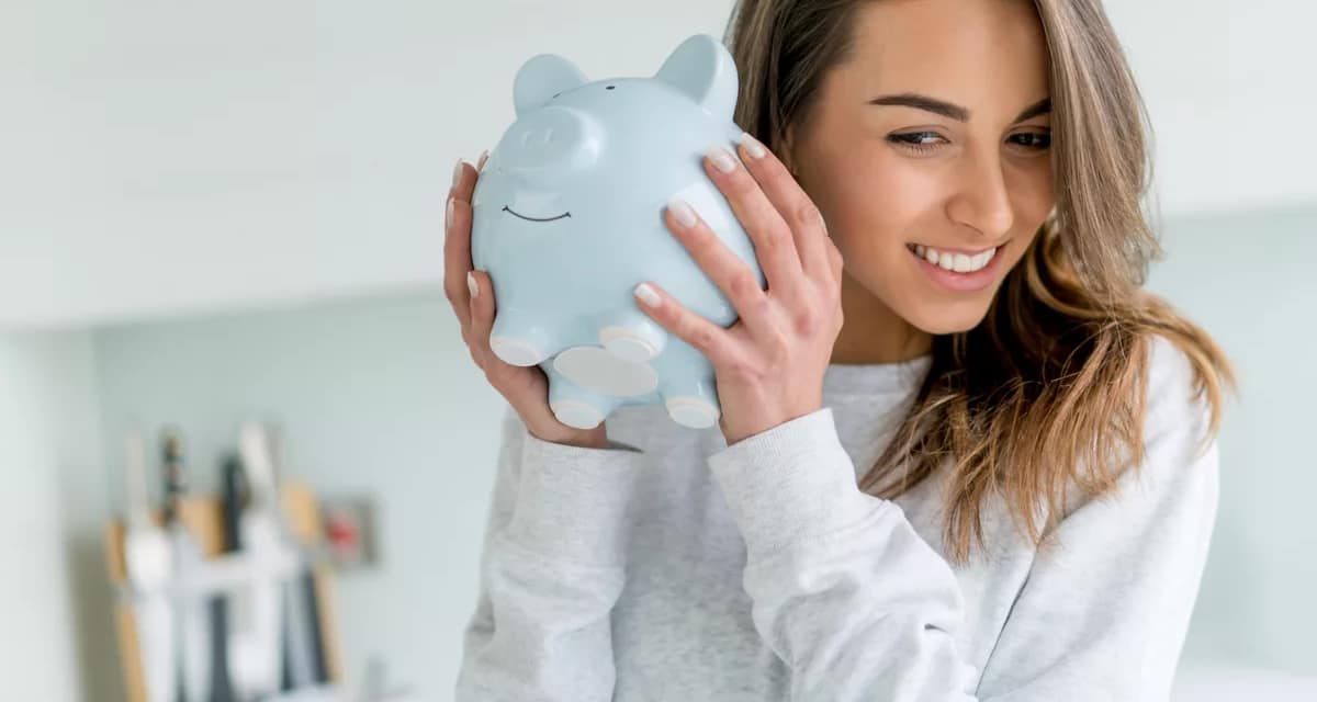smiling person shaking piggy bank.jpg