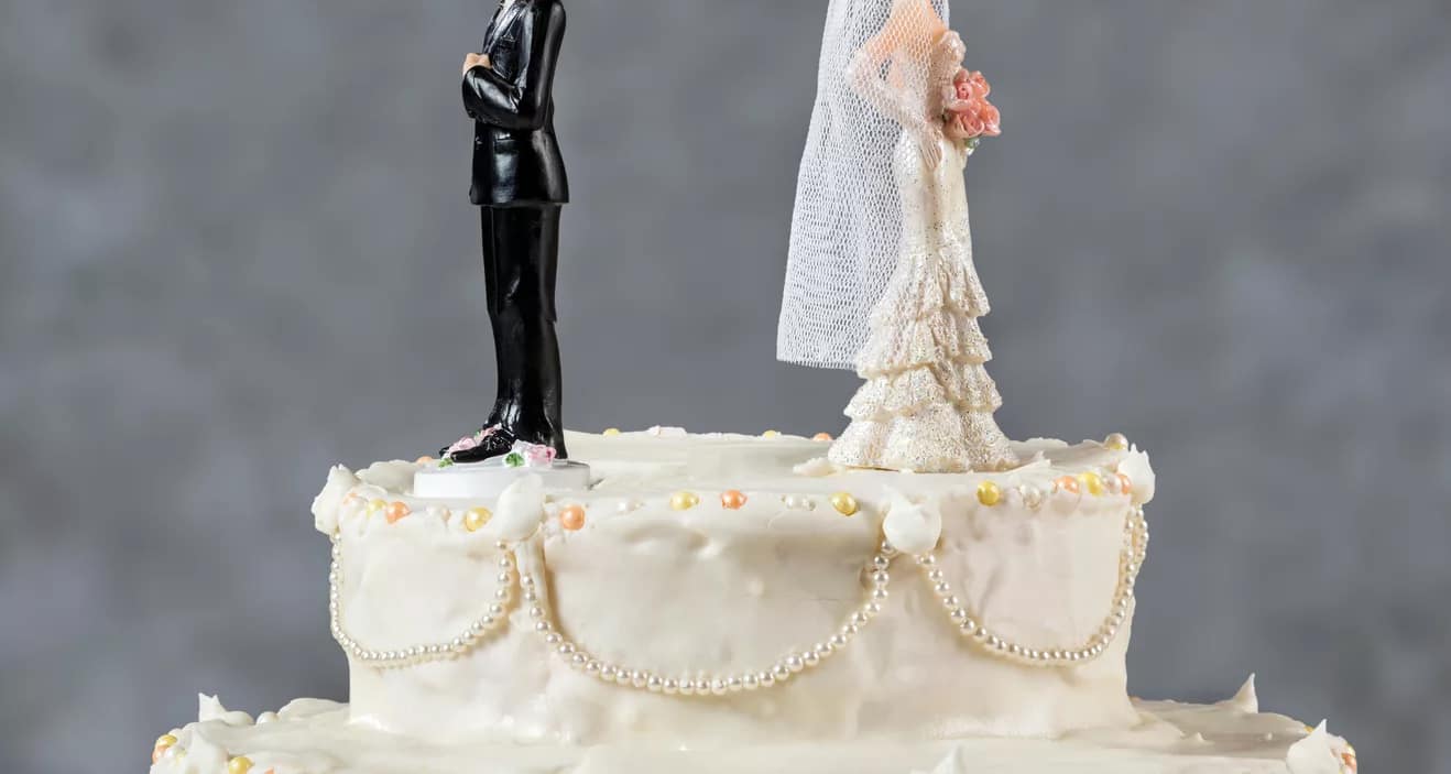 bride and groom figurines facing away from each other on top of wedding cake divorce marriage x afb.jpg