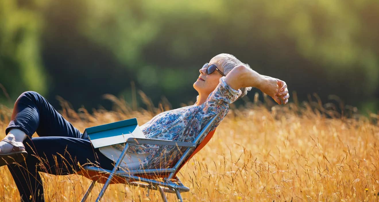 relaxed person with book on lap sitting in field.jpg