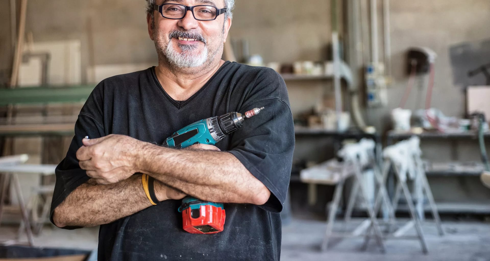 getty smiling happy workers with tool drill blue collar.jpg