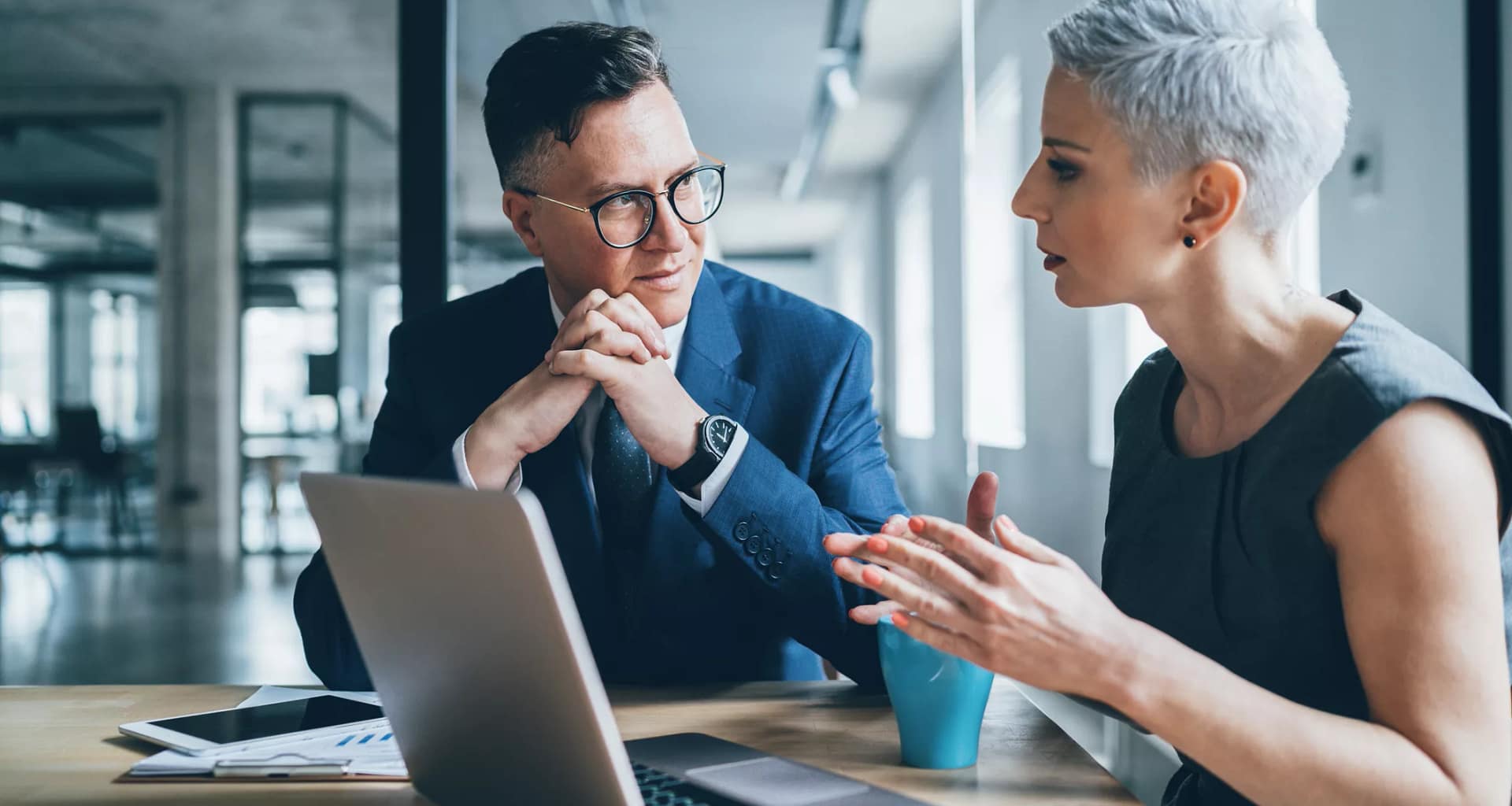 two businesspeople talking in front of a laptop.jpg