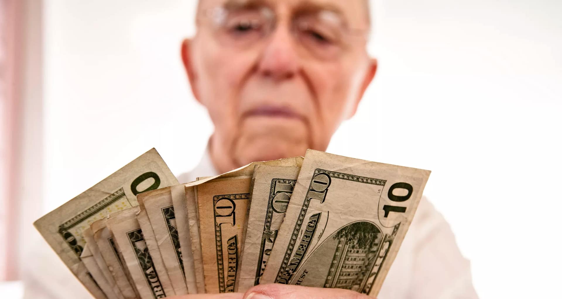 senior holding assortment cash bills social security retire getty.jpg