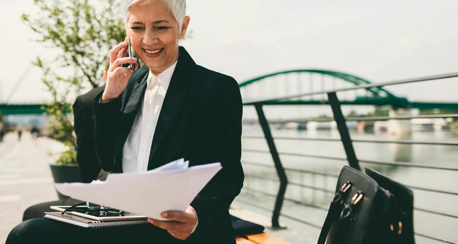 mature senior businesswoman woman on phone looking at documents.jpg