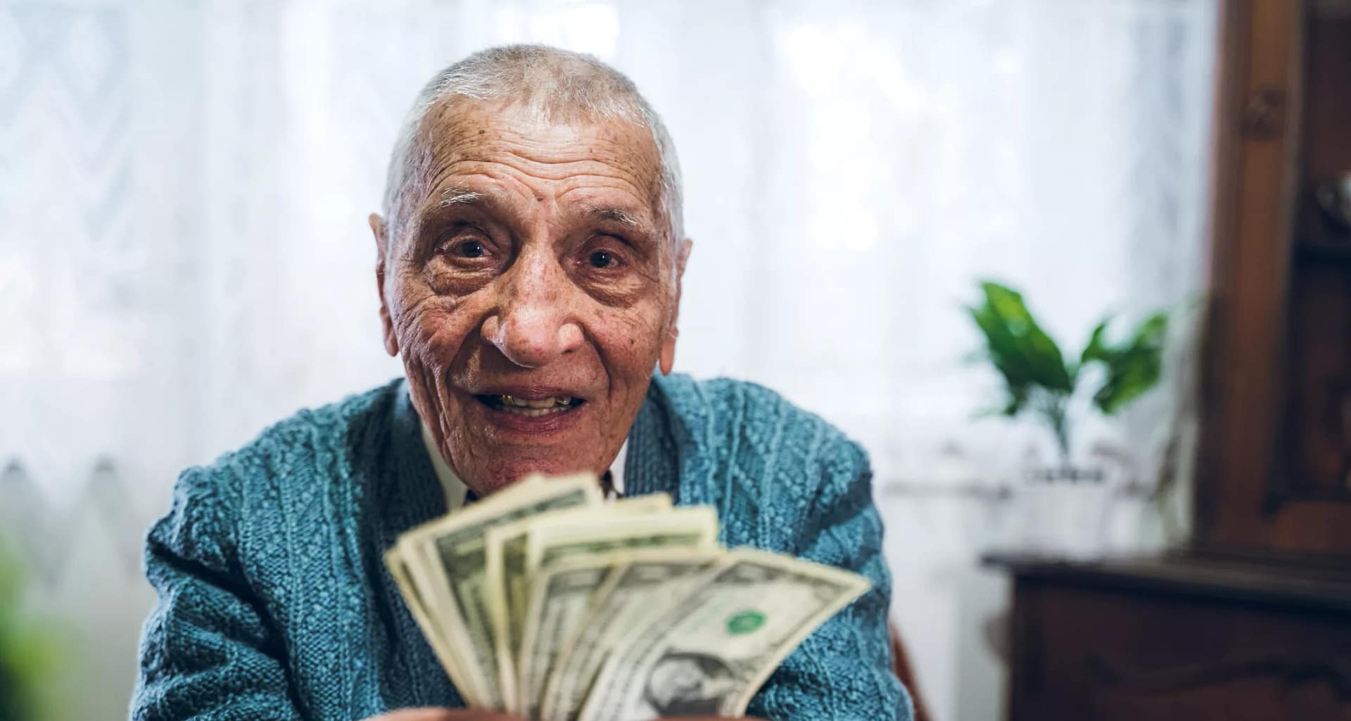 senior man counting cash money bills social security retire invest inflation cola getty.jpg