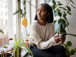 person with phone looking out window ZLNGso.width .jpg